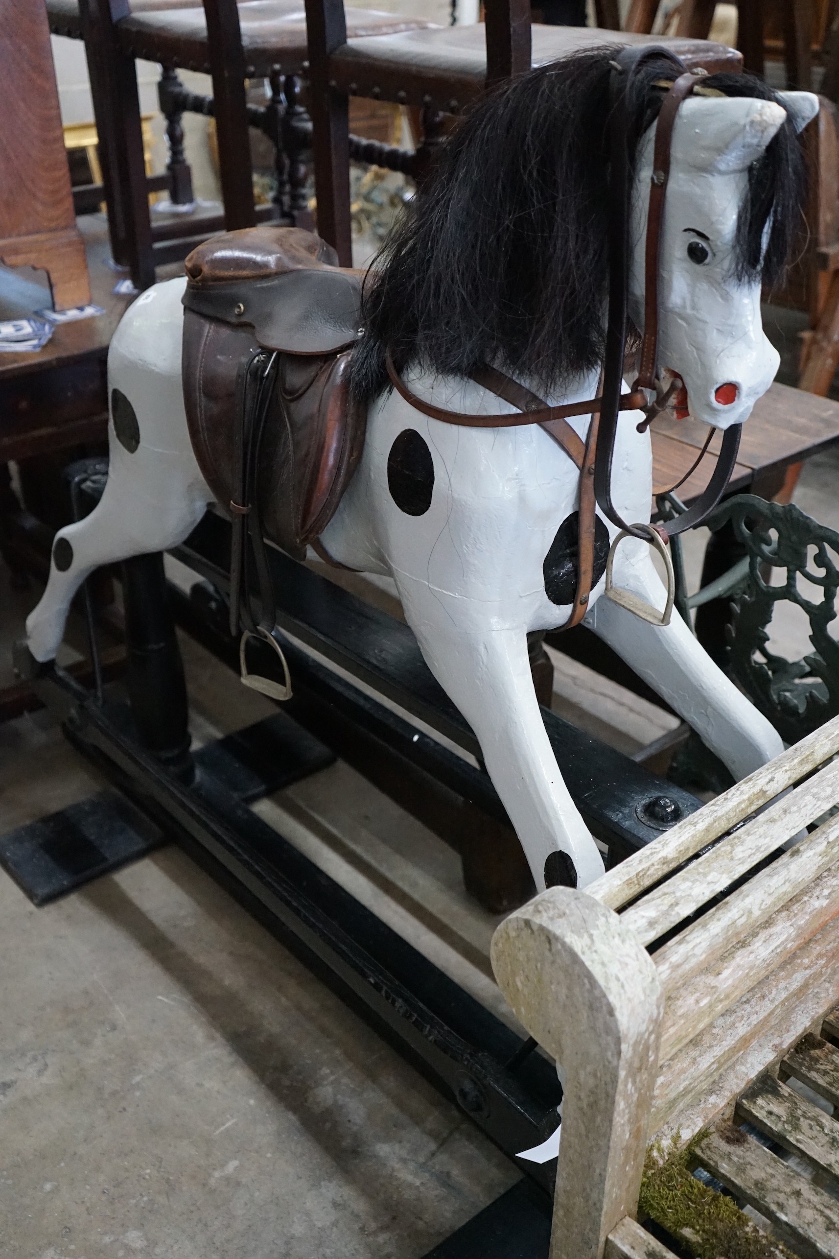 An early 20th century carved wood rocking horse on safety frame (re-painted), height 126cm